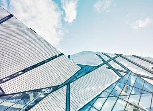 Modern glass building against a blue sky.