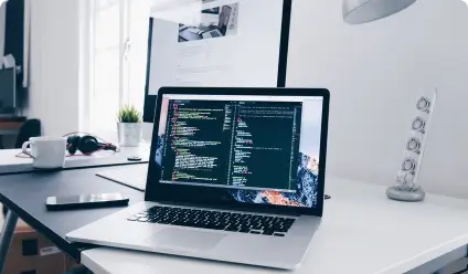 Laptop on a desk with code displayed.